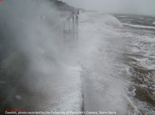 Photo of waves overtopping sea defences.