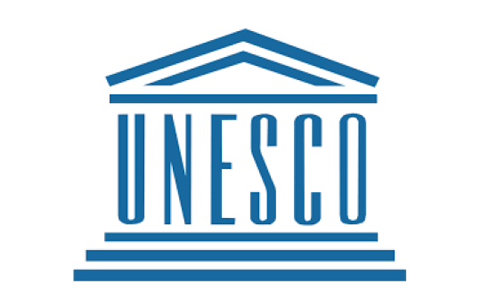 Blue letters UNESCO on white background, resembling pillars atop steps.